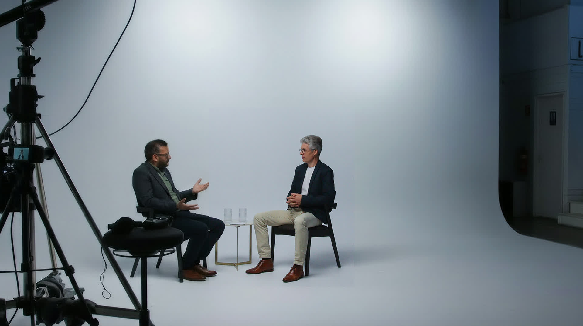Behind the scenes on a Tekspace video shoot, camera and lighting rigs framing two people mid-conversation